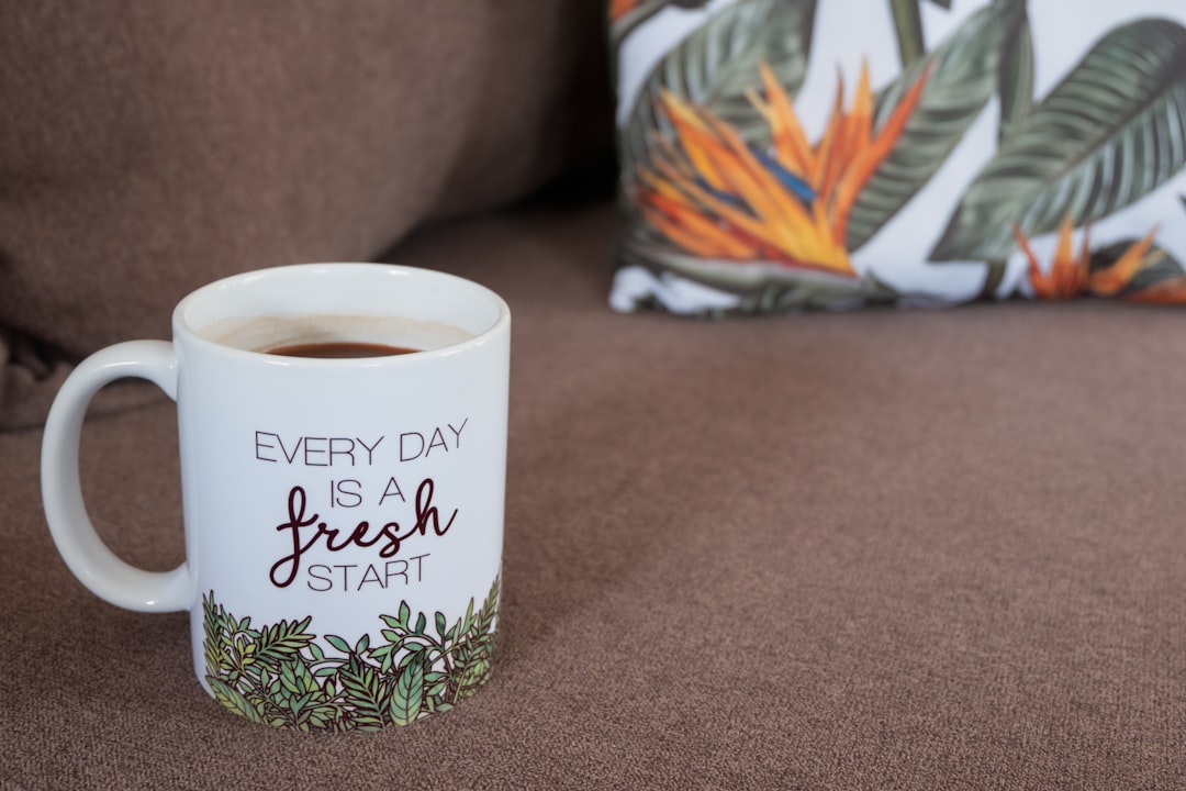 a-coffee-mug-on-a-couch-with-a-pillow-sl8hui5sik4